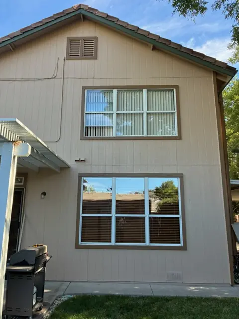 Before: Rear windows of a two-story home, solar screens