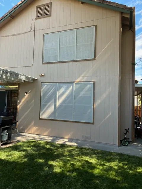 After: The same two-story home from the patio corner, solar screens